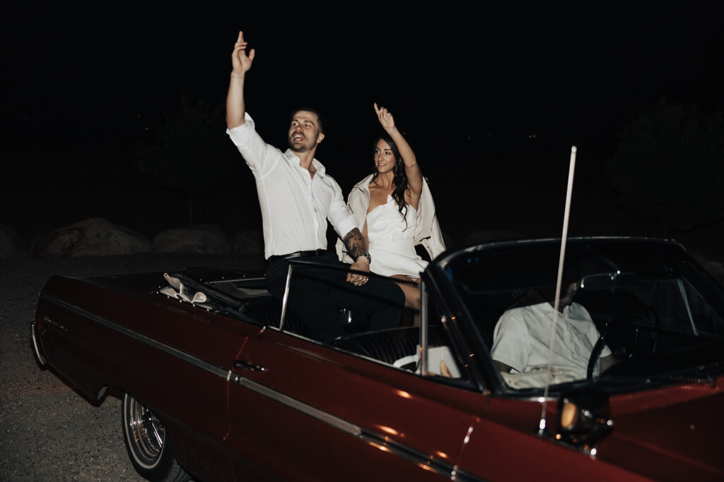 Bride and groom drive off in a vintage car